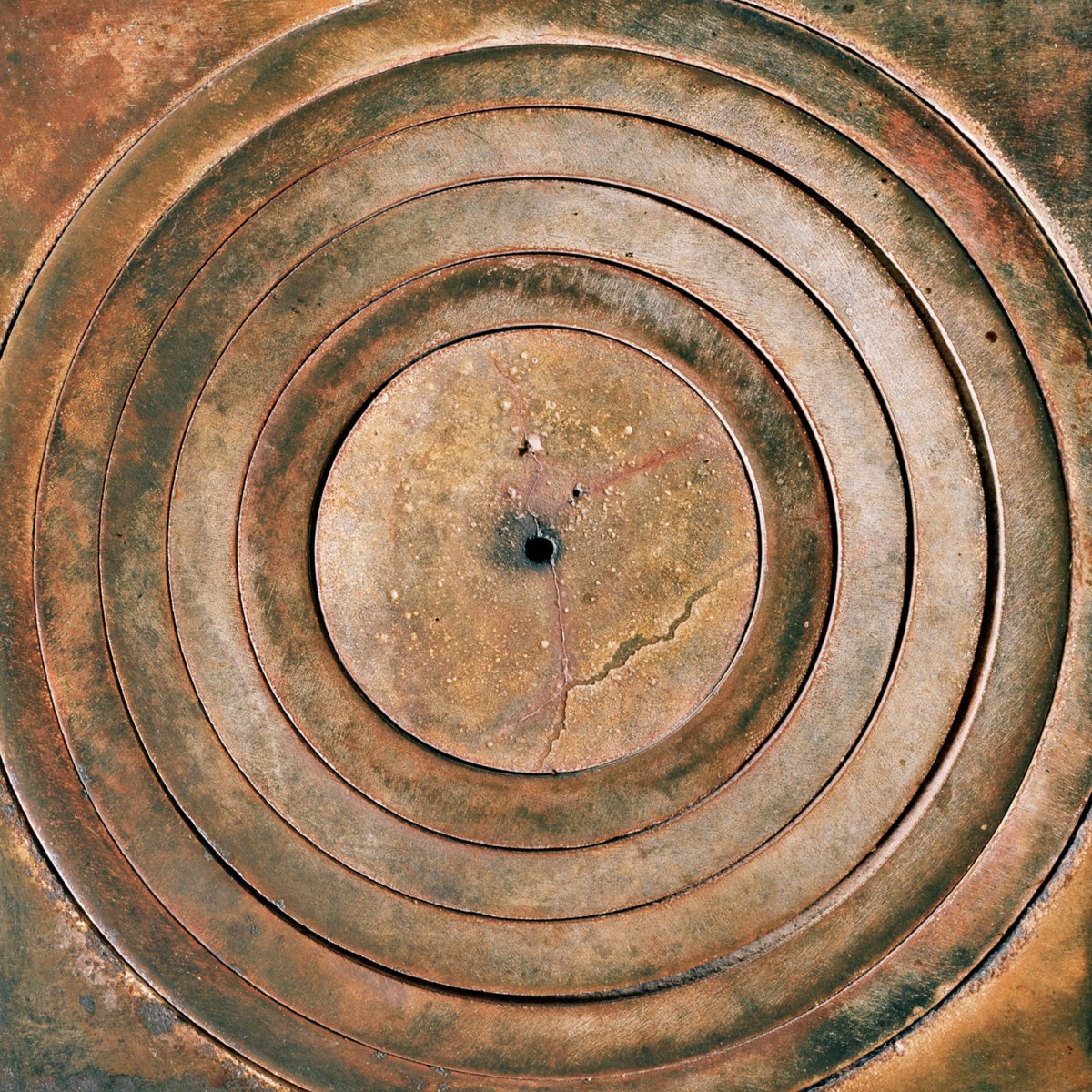 Detail of Segreto 18 / Secret 18: concentric cast-iron rings on an old kitchen stove, from Nel segreto di una casa / In the Secrecy of a Home, 2024